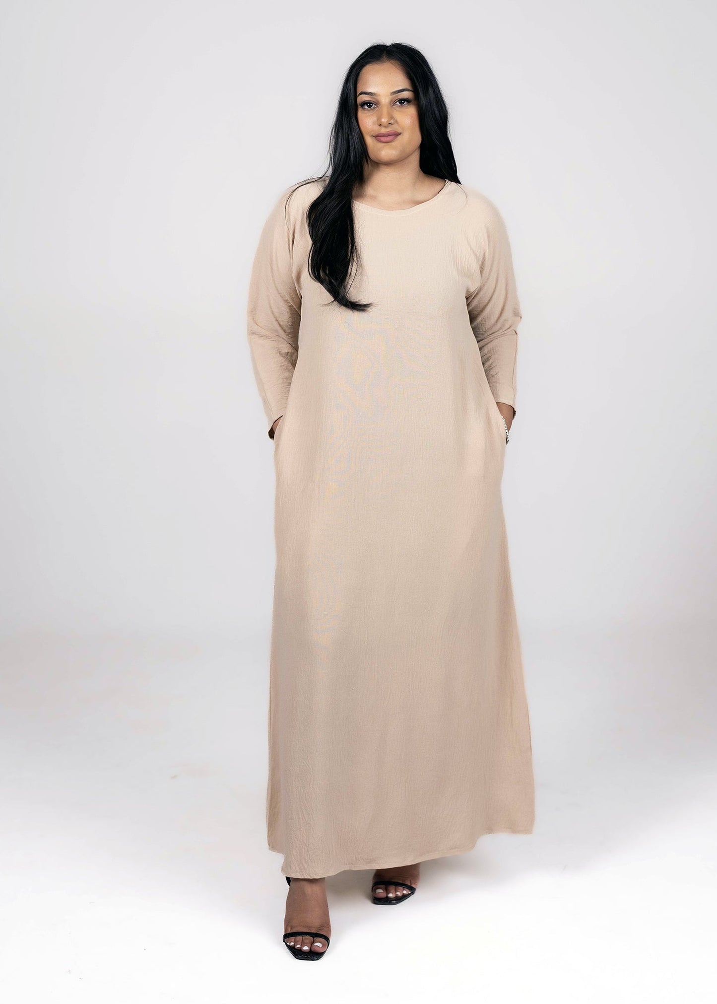 woman wearing a full sleeve modest slip dress in beige