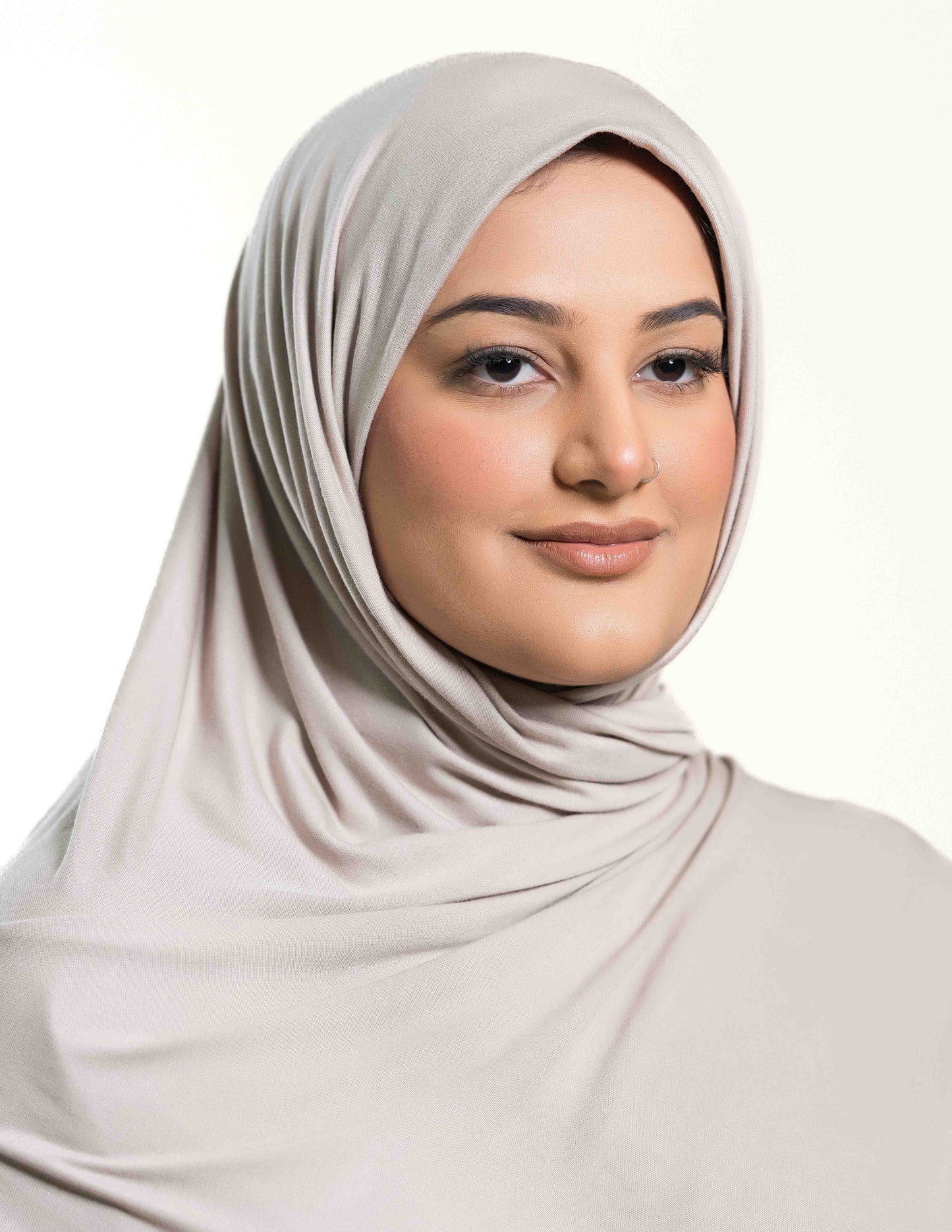 A woman wearing a light grey jersey hijab.