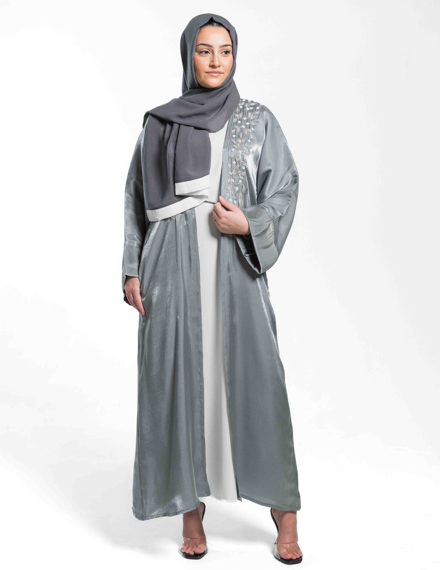 A woman wearing a Marinaa abaya paired with a matching hijab, showing the full front view and fabric details.