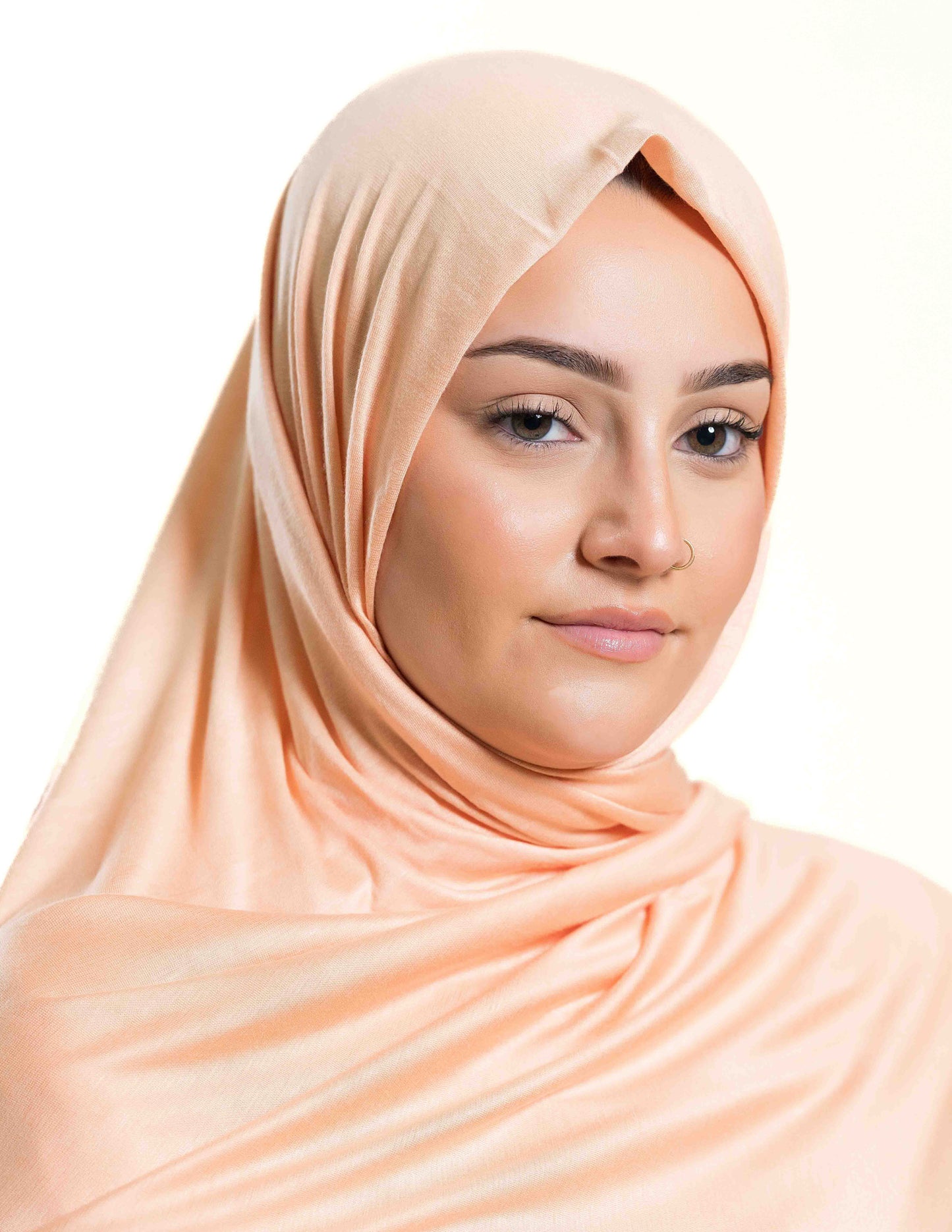 A woman wearing a peach-colored jersey hijab.
